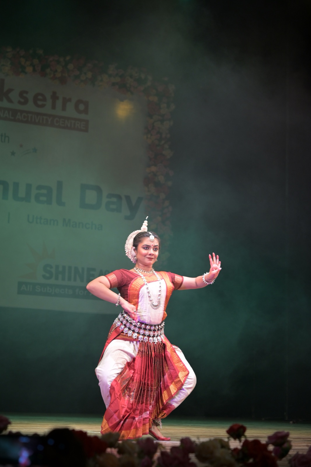 Odissi dancer mid-movement with one hand raised in an expressive gesture